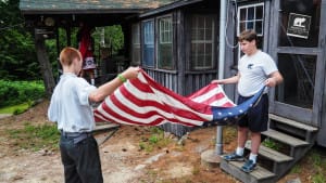 Campers work together to properly fold the American flag