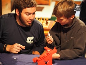 Archery instructor teaches camper how to repair arrows