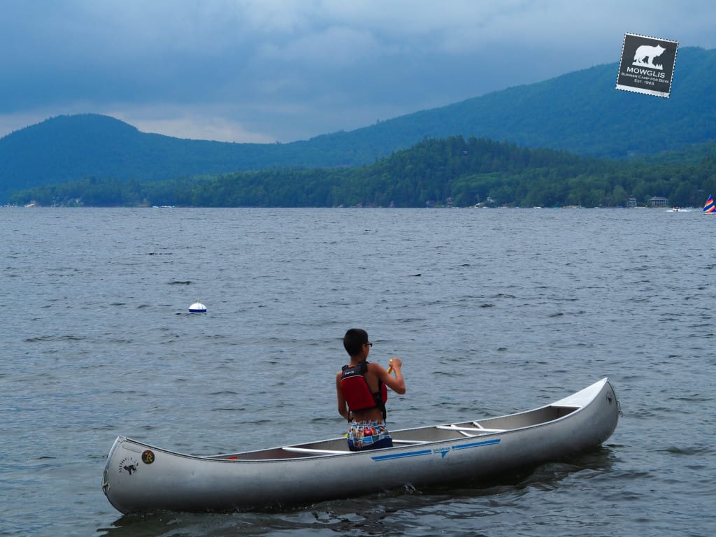 Camper practices canoeing solo as he works towards the "Red Ribbon" or canoeing ribbon