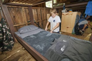 Camp Mowglis campler making their bed